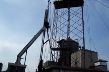 The chimney liner was going to be too close per the building code to the water tower, so it had to be extended above the tower and welded to a bracket, and secured by cables down to the roof. This chimney liner was ultimately 200' high due to the extension required because of its proximity to the water tower and the neighboring building.