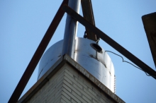 This is the same building showing the chimney liner protruding above the masonry chimney, as required by code. The hoisting gear has not yet been removed.
