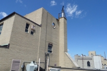 This is the same building showing the chimney liner protruding above the masonry chimney, as required by code. The hoisting gear has not yet been removed. This photo shows the 45 degree angle