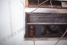 LL87/09 energy auditor will recommend weather sealing and insulating this tenant-installed A/C through-the-wall unit, which is totally exposed to the outside. © 2015 IntelliGreen Partners LLC